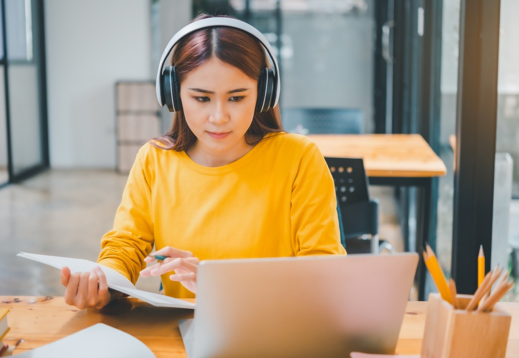 Illustration - Jeune femme suivant un cours particulier de langue étrangère en e-learning avec casque et ordinateur via le programme de coaching