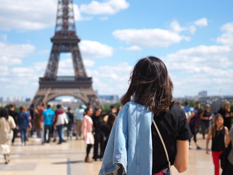 Étudiants internationaux découvrant Paris devant la Tour Eiffel, illustrant l'apprentissage du français en contexte réel